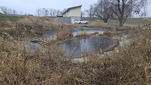 Side view of house across filled pond Nov 30, 2024